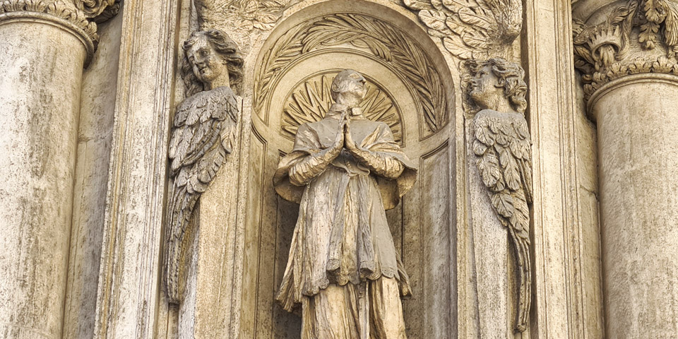 Saint Charles Borromée en prière encadré par des anges sculptés