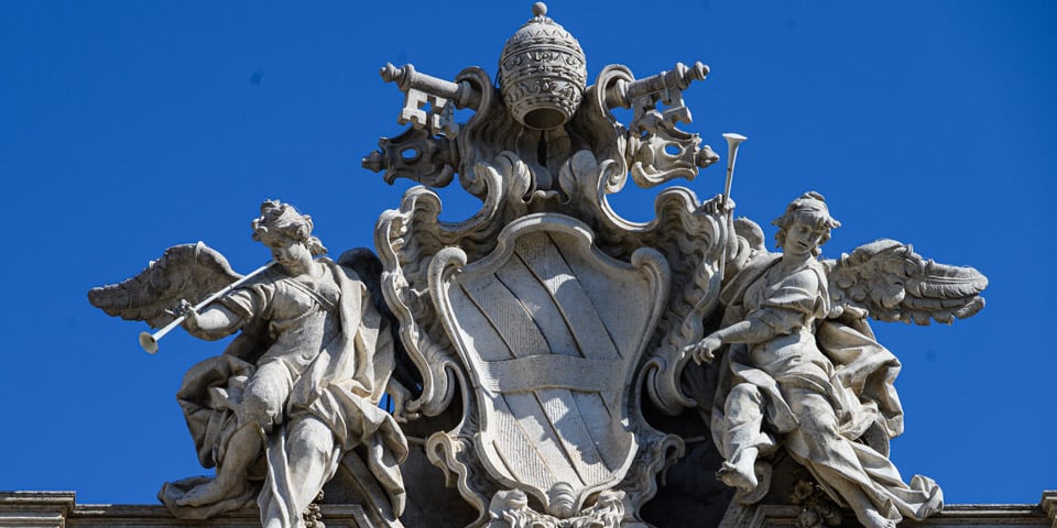 La tiare pontificale et l’écu héraldique au sommet de la fontaine de Trevi