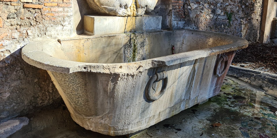 Le bassin sous la fontaine du masque provient d’un ancien bain thermal romain