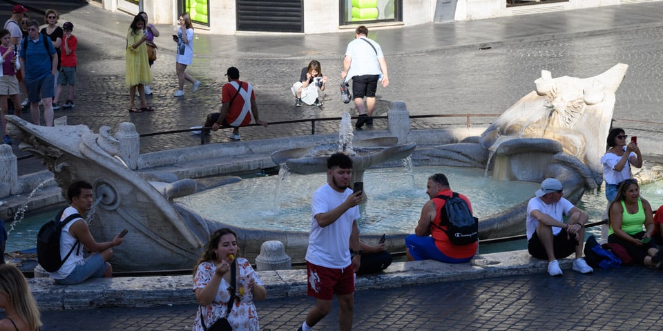 Des touristes se détendent et prennent des photos près de la fontaine de la Barcaccia à Rome. Des touristes se détendent et prennent des photos près de la fontaine de la Barcaccia à Rome.