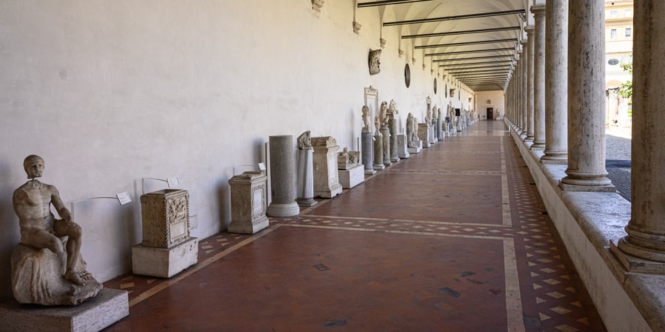 Longue galerie à colonnade du grand cloître bordée de statues et d’autels romains antiques, Thermes de Dioclétien à Rome