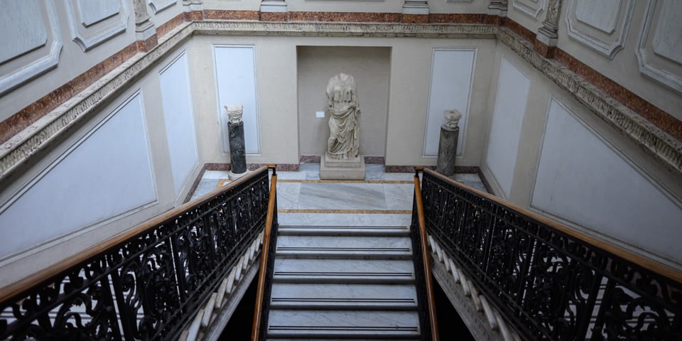 Escalier en marbre avec rampe en fer forgé et statue antique au Musée national romain, Thermes de Dioclétien à Rome