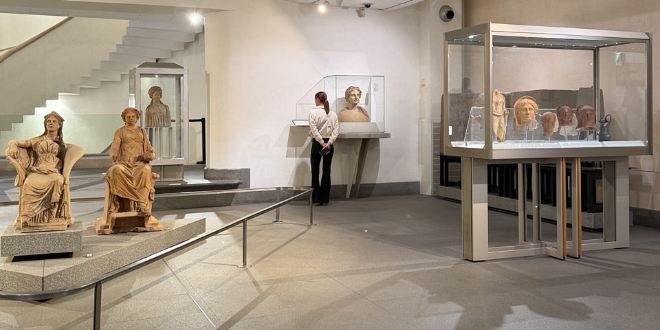 Galerie intérieure du Musée national romain avec statues antiques et bustes dans des vitrines, Thermes de Dioclétien à Rome