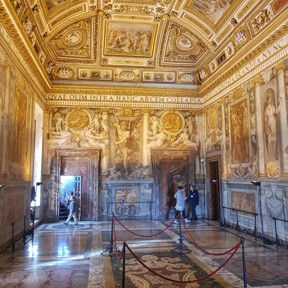 Sala Paolina ornée de fresques, avec plafond à caissons dorés et frise latine à l’intérieur du Château Saint-Ange, à Rome