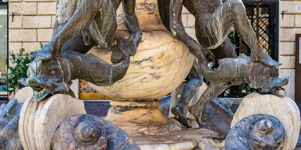 fontaine des Tortues à Rome gros plan sur les détails des sculptures d’un jeune homme et d’un dauphin
